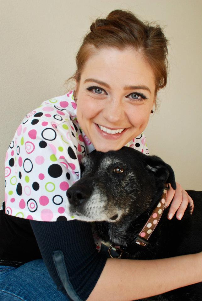 Dr. Alisha Barnes hugging a dog after treating by chiropractic care